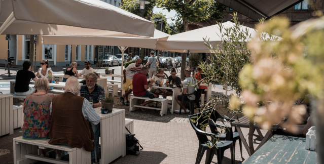 Besetzte Außentische bei Sonnenschein