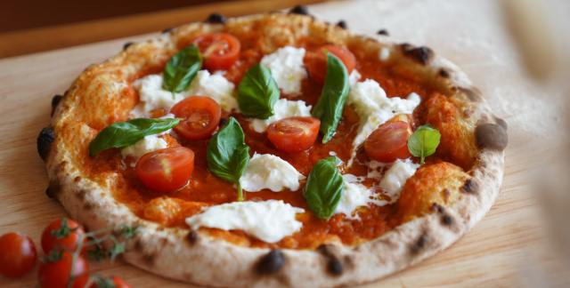 Pizza belegt mit frischen Kräutern und saftigen Tomaten