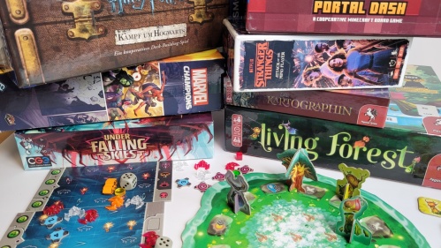 Ran ans Brett Eine Ansammlung von Brettspielboxen und Spielmaterialien verschiedener Designs und Themen. Die Boxen sind übereinander gestapelt und auf einem weißen Untergrund angeordnet. Auf einigen Boxen sind Bilder von Comicfiguren, Filmen und fantasievollen Motive